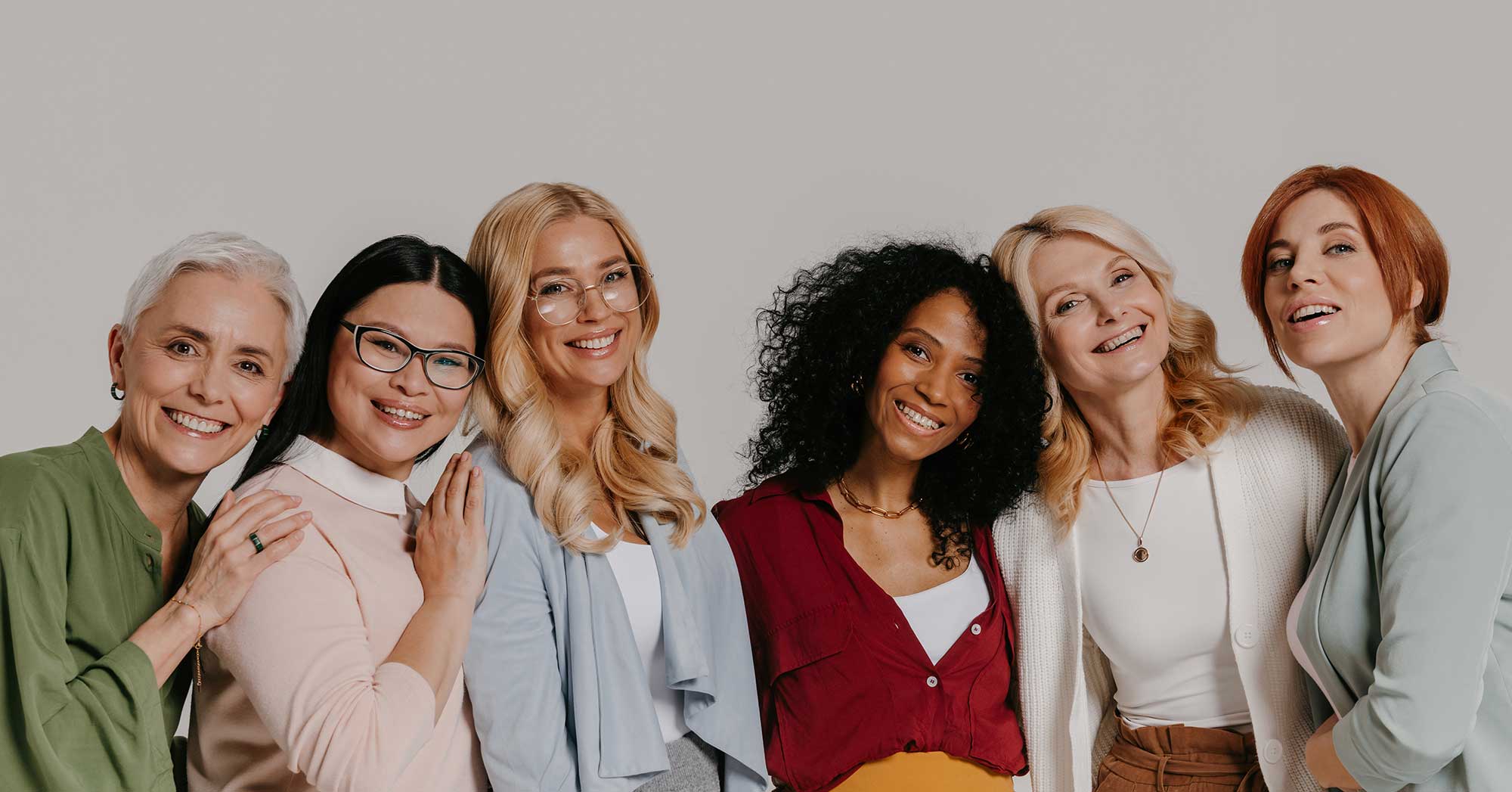 Group of women posing together against a plain background